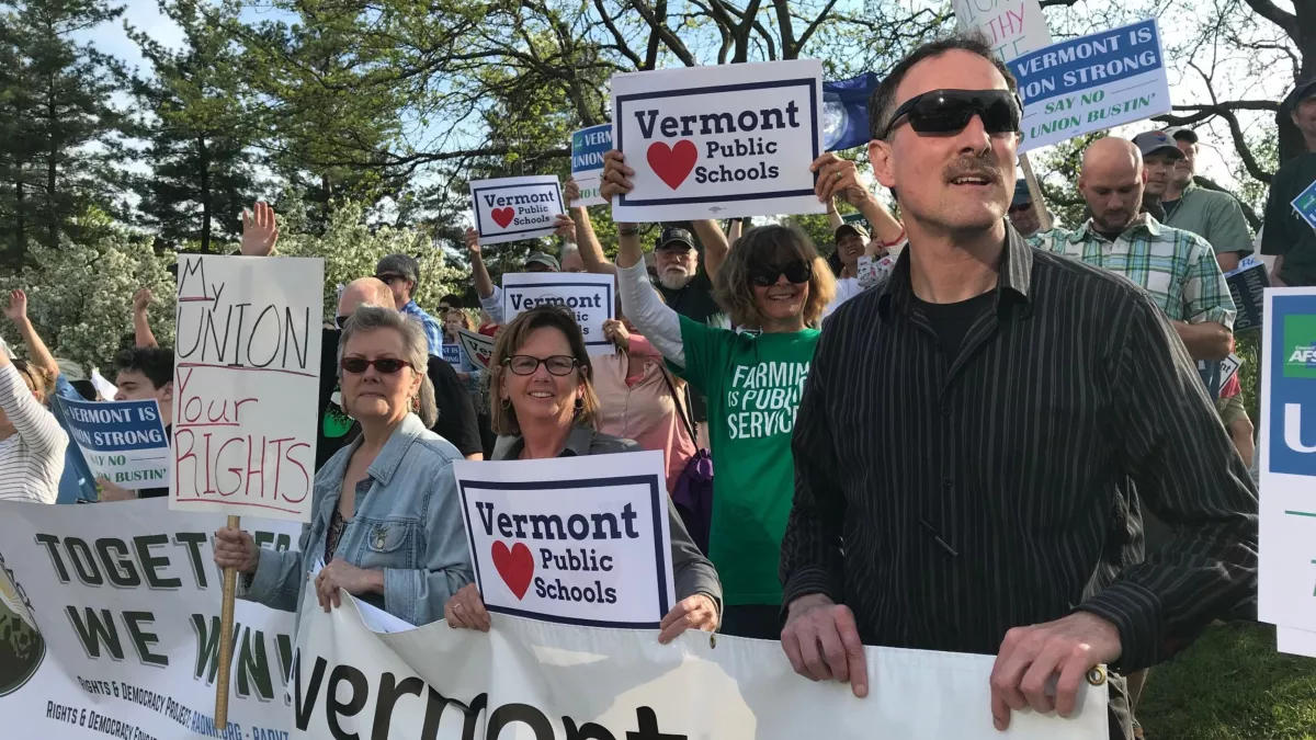 VT-NEA members hold a sign that says "Together we win!"