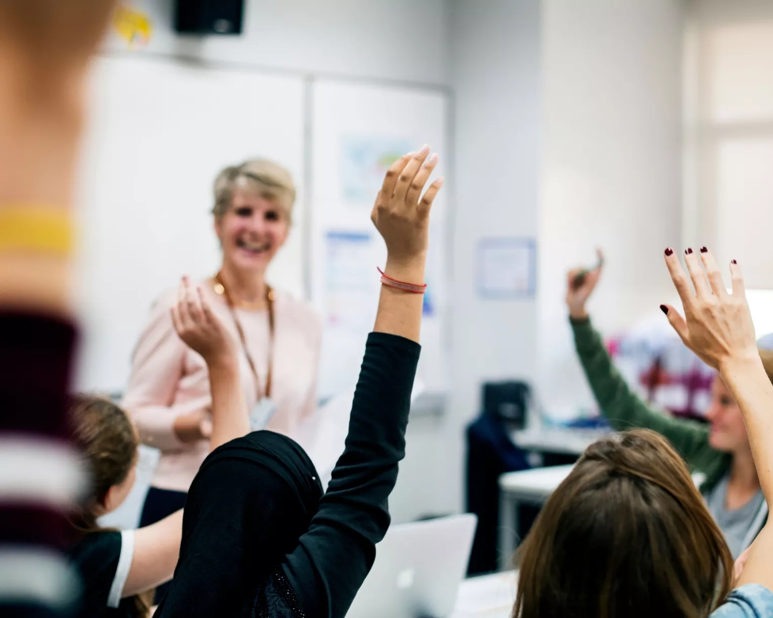 teacher with classroom raising hands
