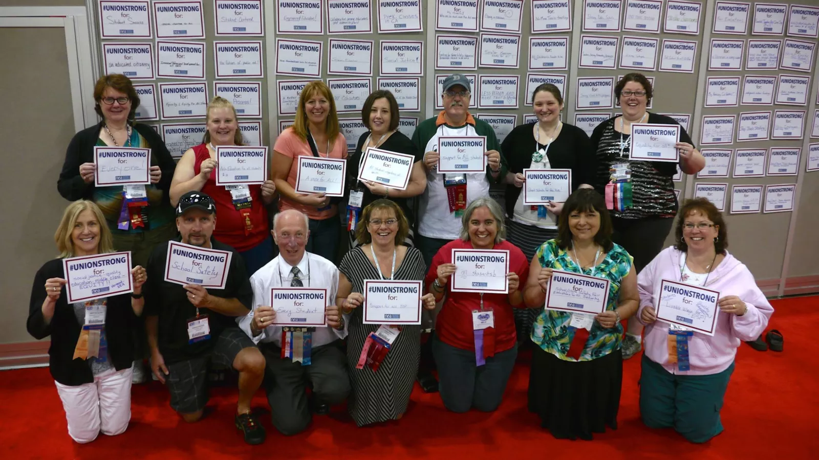 VT-NEA members pose with signs that say, "I'm Union Strong for..."