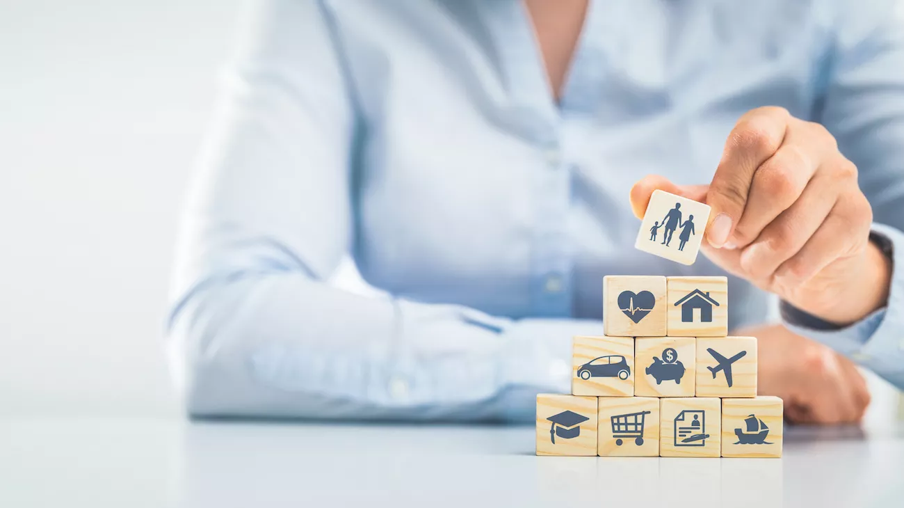 Woman stacks blocks with symbols of family, money, education, etc.
