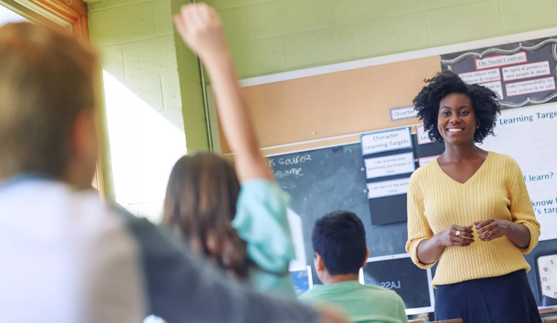 Black teacher smiles in classroom