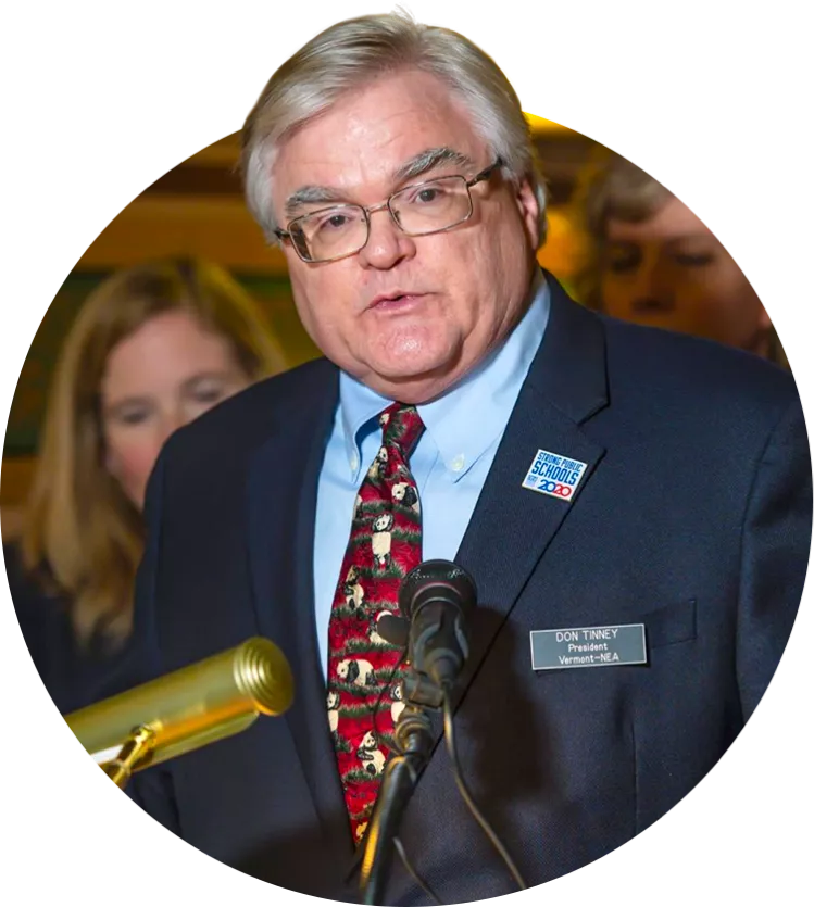 VT-NEA President Don Tinney speaks into a microphone.