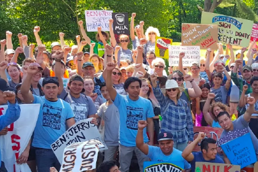 VT-NEA members stand together with their fists up in solidarity.